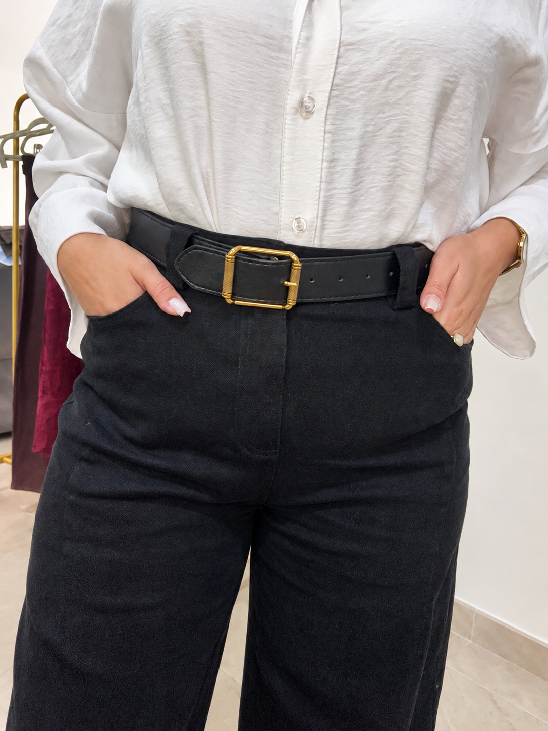 Gros plan sur la taille du jean Allie noir, ses poches avant et sa ceinture à boucle métallique.