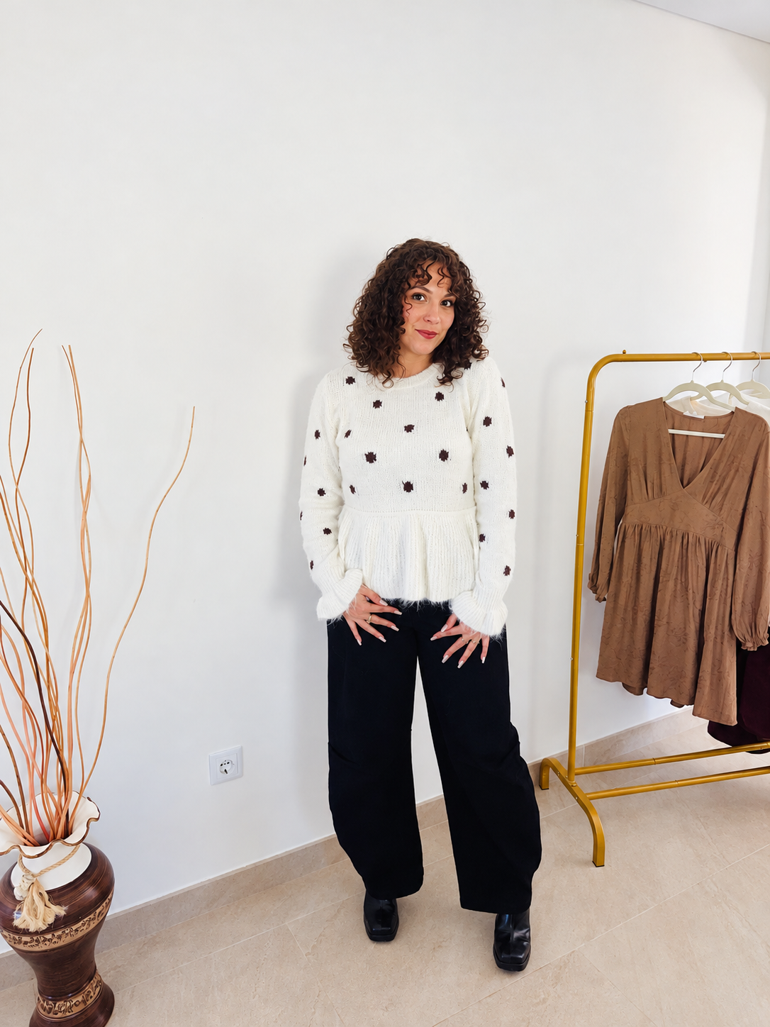 Pull Rosalie beige clair à pois et volants, porté de face avec un pantalon noir.