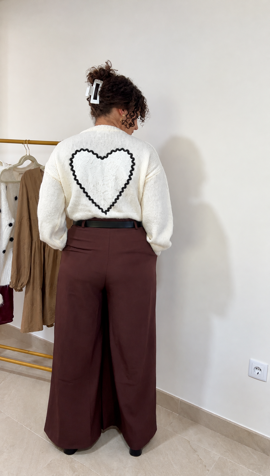 Gilet Amor beige clair vu de dos, avec un grand cœur en dentelle, porté avec un pantalon marron.