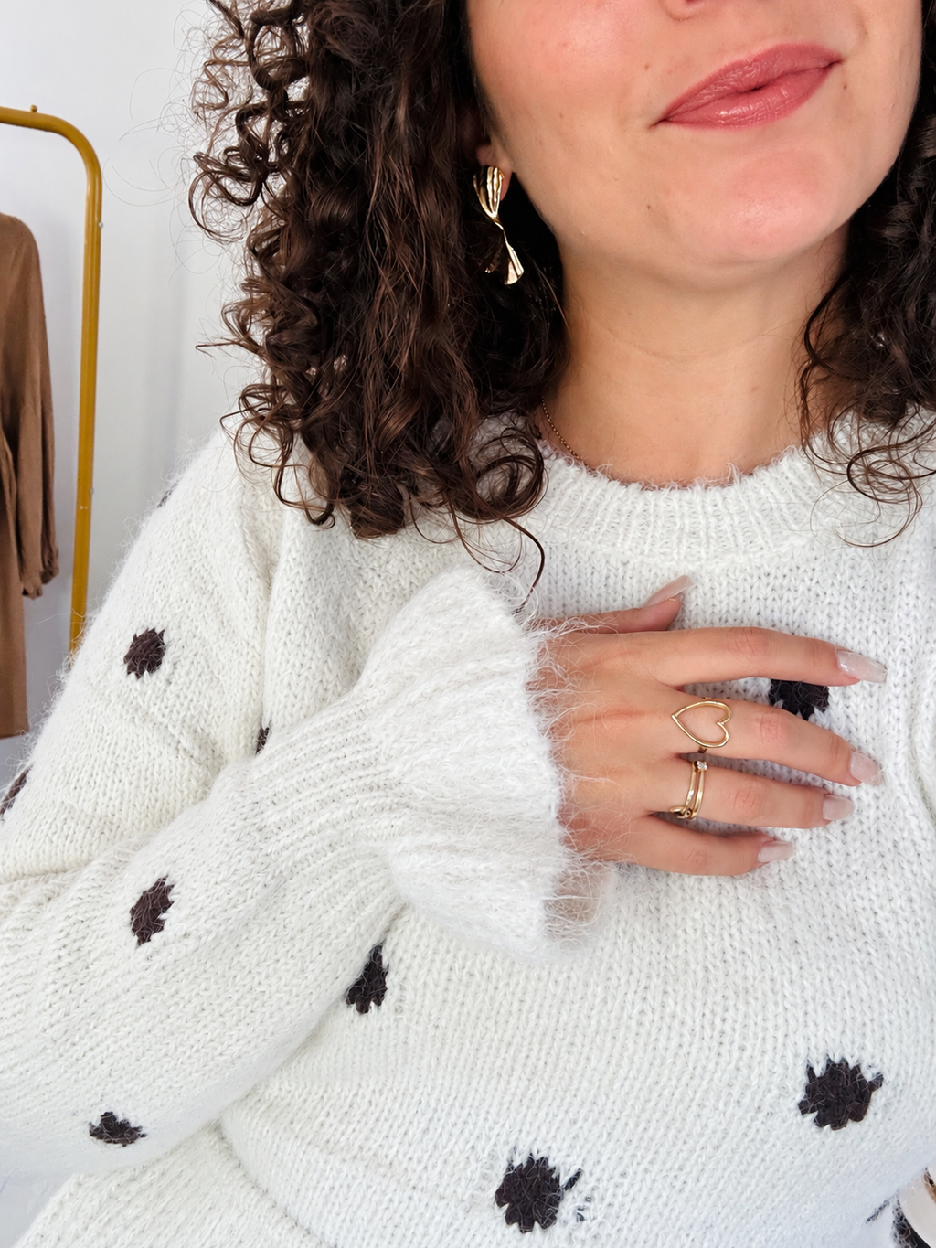 Gros plan sur la maille à pois du pull Rosalie, son col rond et le bord de sa manche.