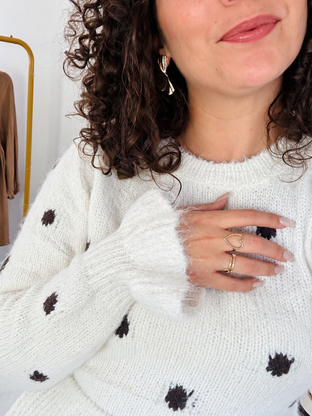 Gros plan sur la maille à pois du pull Rosalie, son col rond et le bord de sa manche.