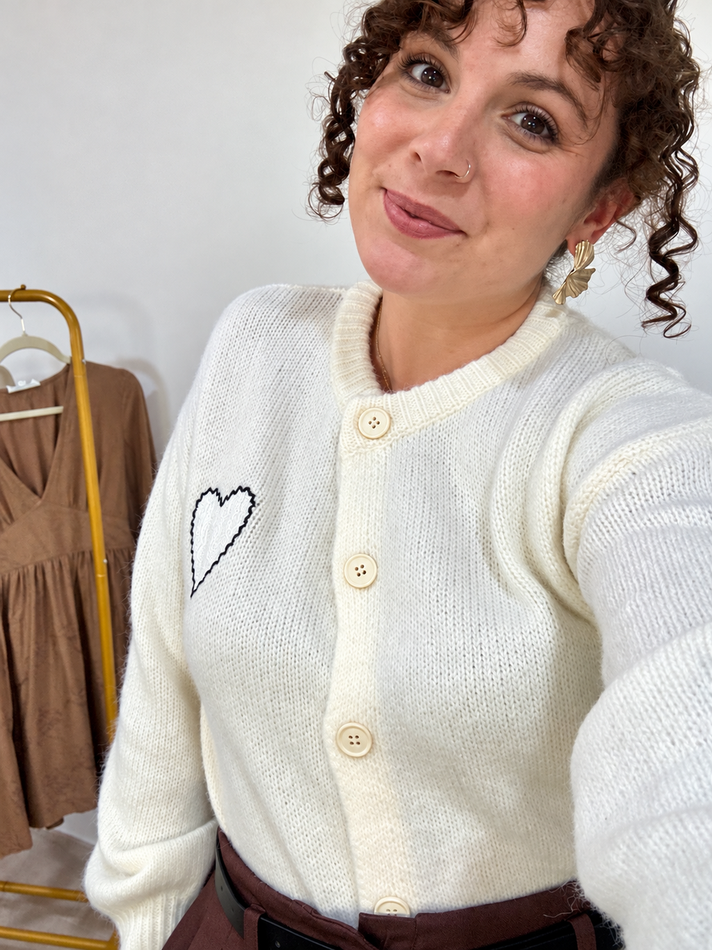 Vue rapprochée du devant du gilet Amor beige clair, montrant son encolure et sa fermeture boutonnée.